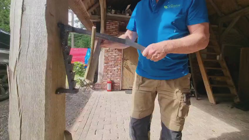 man doet voor hoe de Stikkan houtklover in zijn werkt gaat, hij klooft een stuk hout voor aanmaak hout.